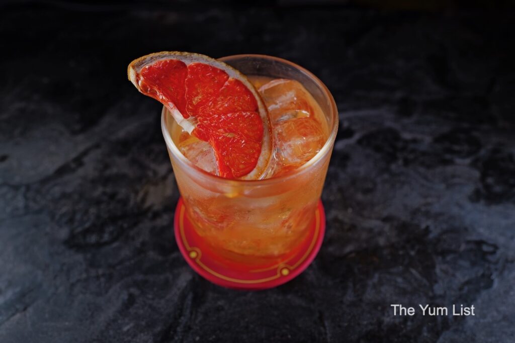 Desire Speakeasy Plaza Batai Figment cocktail with dehydrated grapefruit garnish
