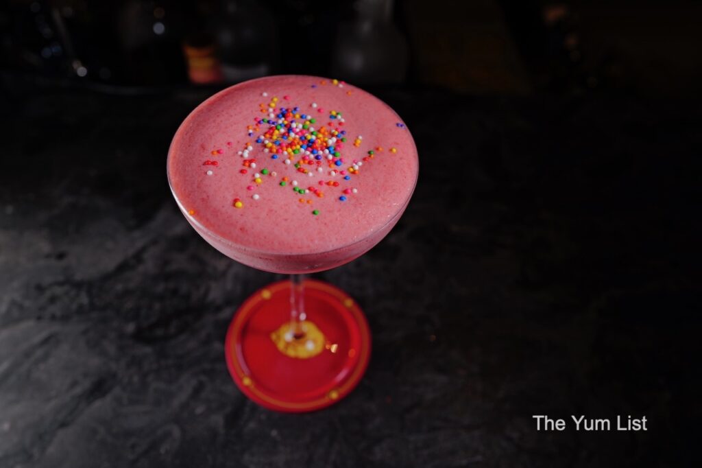 Desire Speakeasy Plaza Batai - The Empress pink cocktail with sprinkles garnish