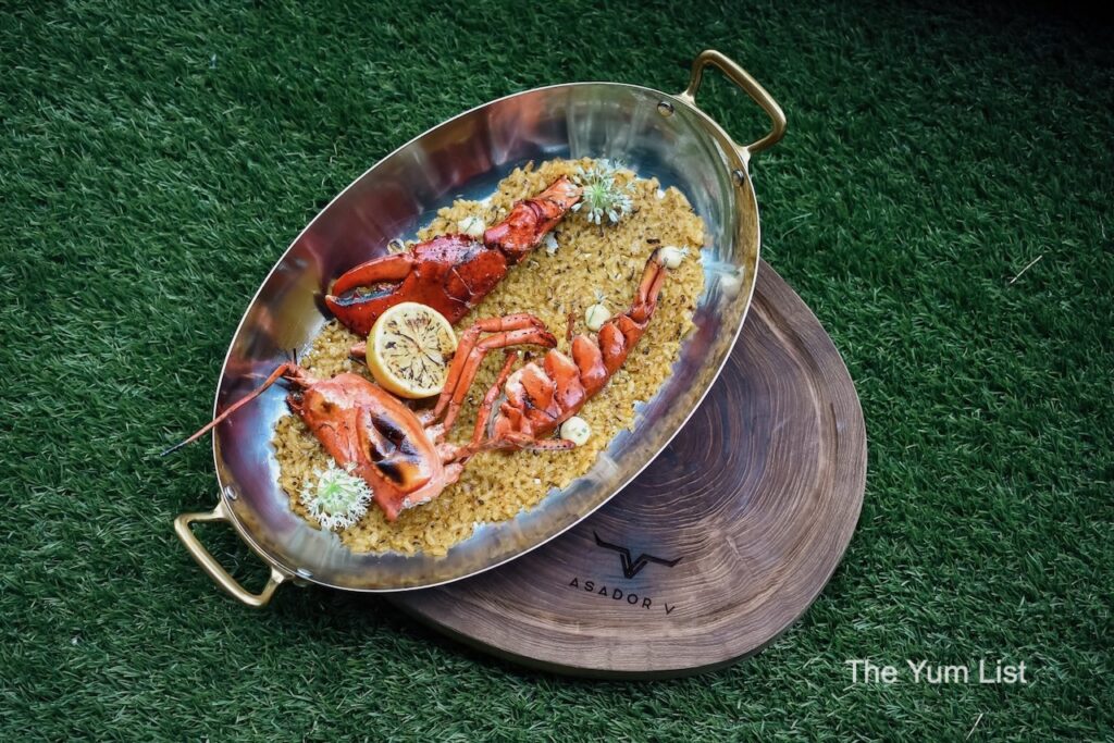 Beautiful steakhouse restaurant KL Lobster Paella in metal dish on wooden board