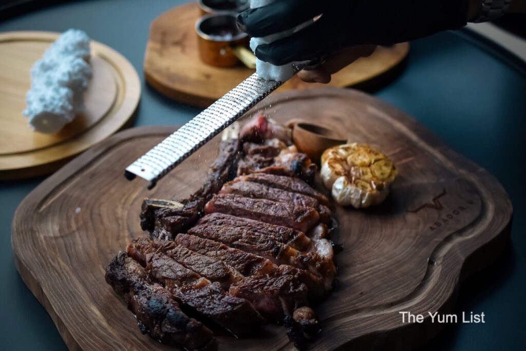 Salt from the Valle Salado de Añana and steak with bone-in on wooden board Asador V KL Steakhouse