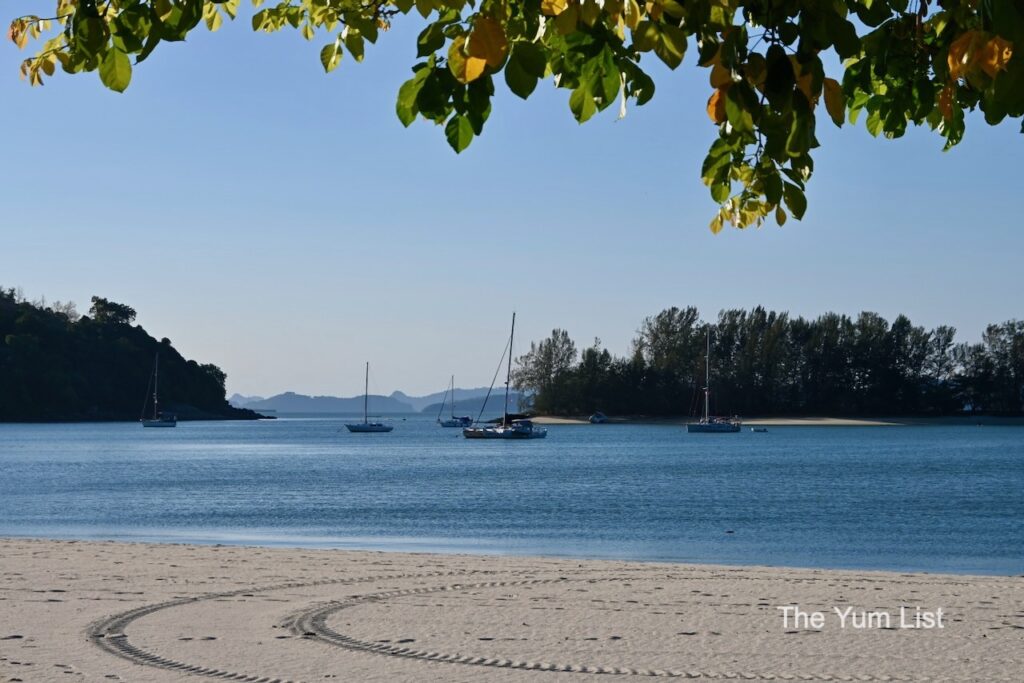 Malaysia's Top Luxury Stays white sand beach with boats in background